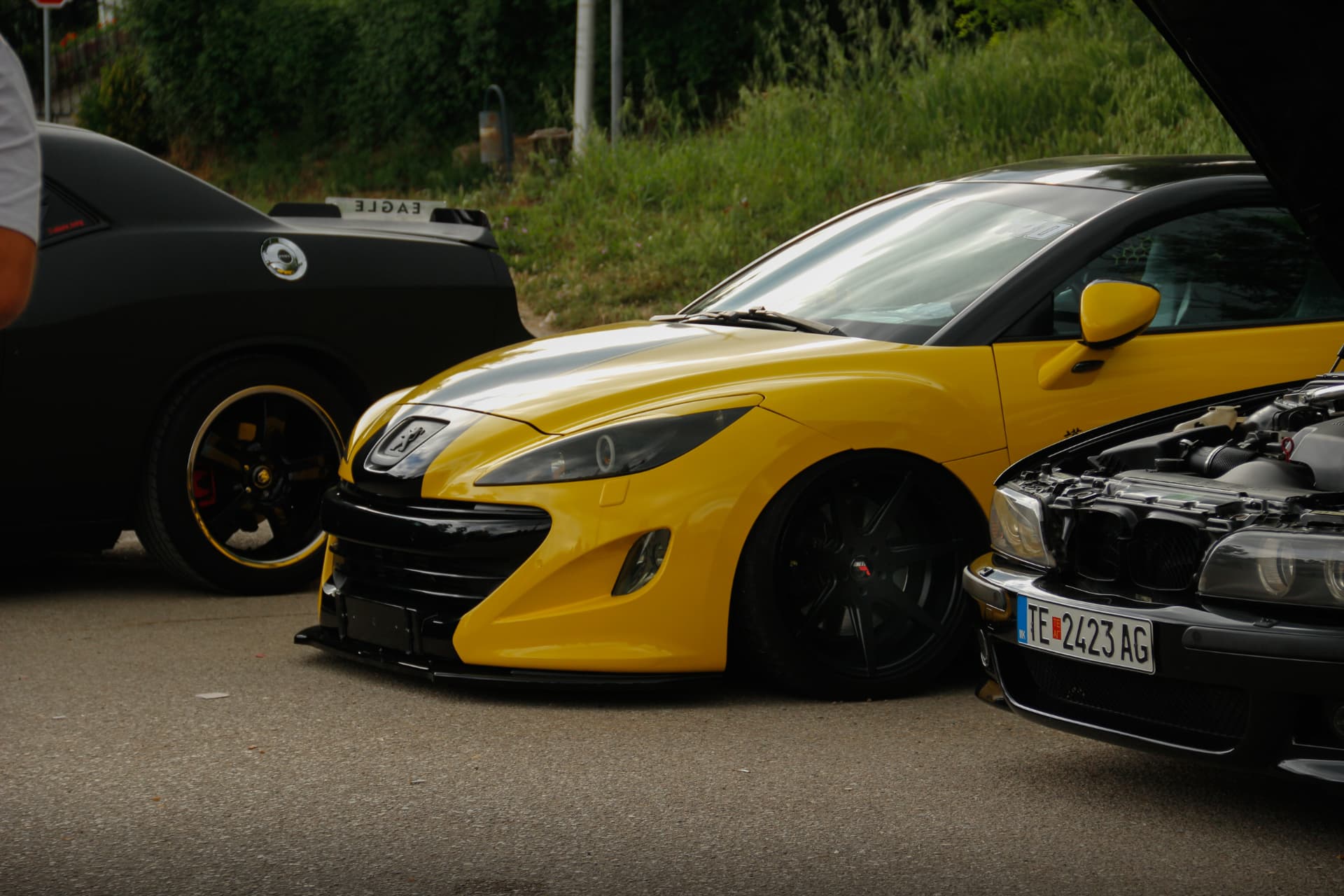 Yellow Peugeot RCZ lowered between parked cars