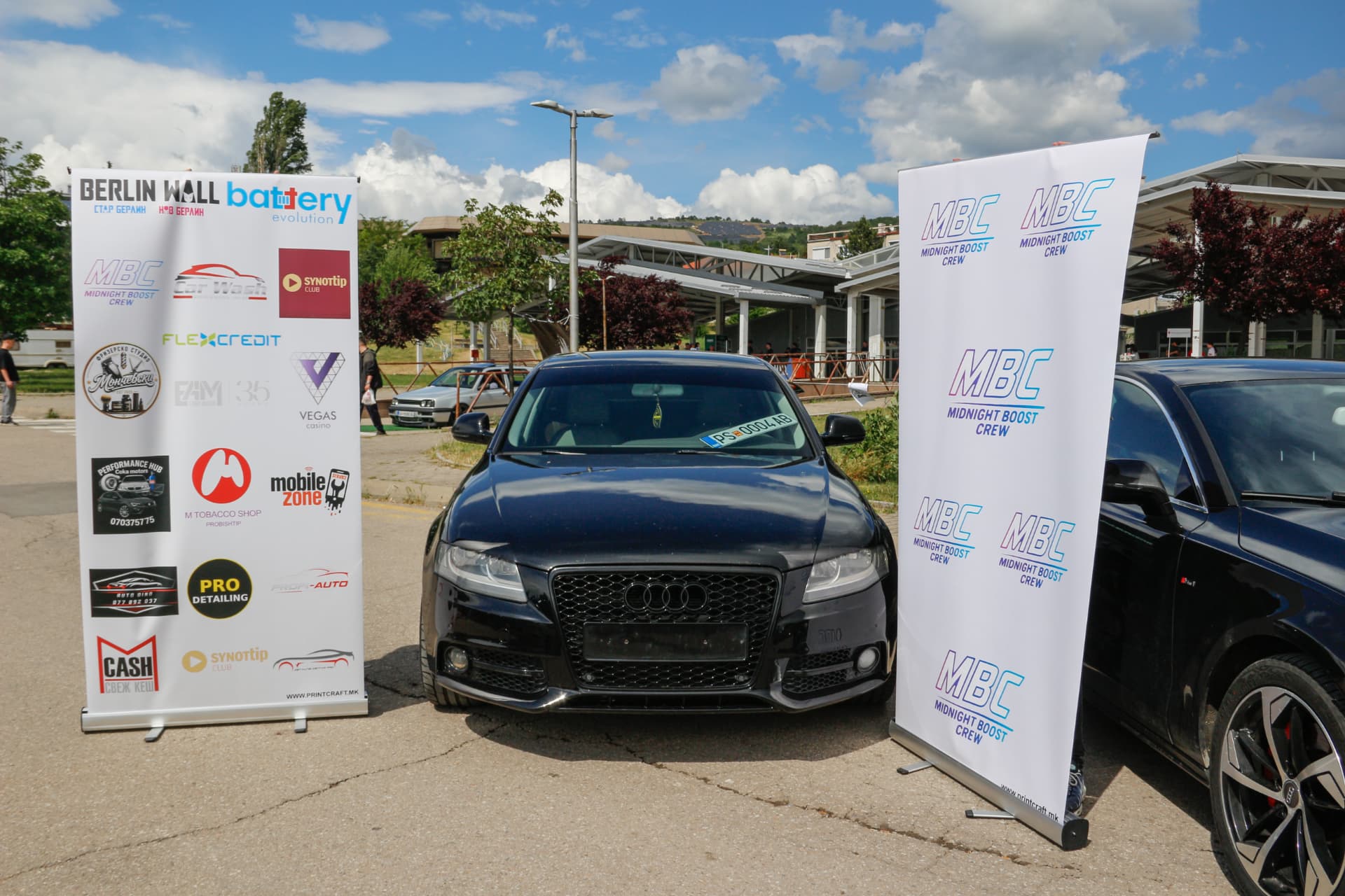 Black Audi A4 between MBC banners