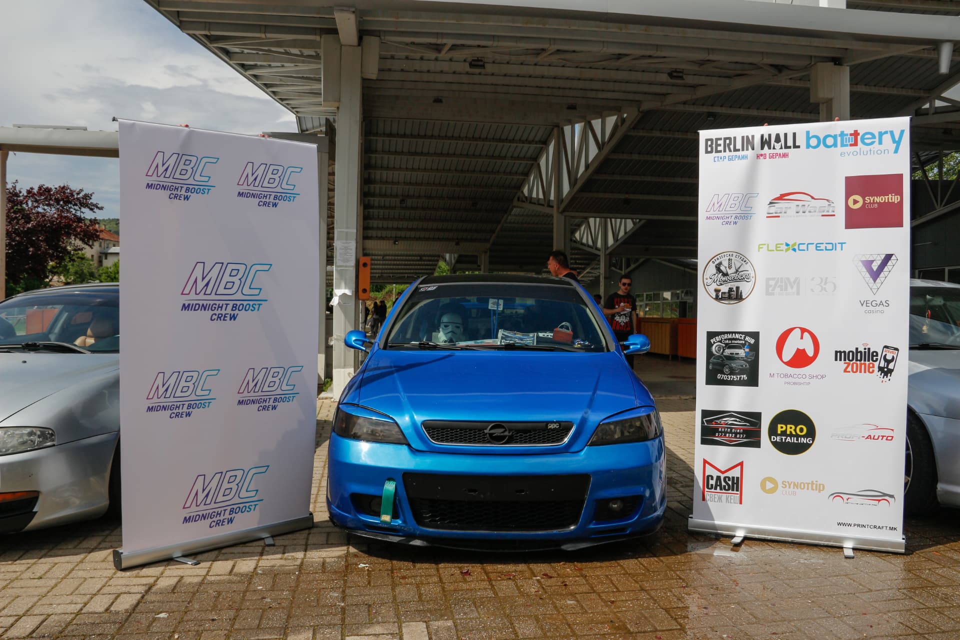 Blue Opel Astra OPC between MBC banners