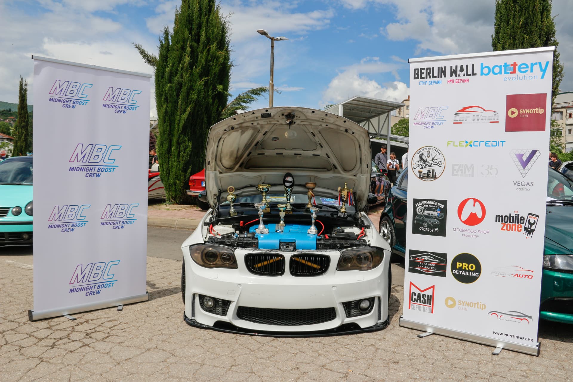 White BMW engine bay with trophies between MBC banners