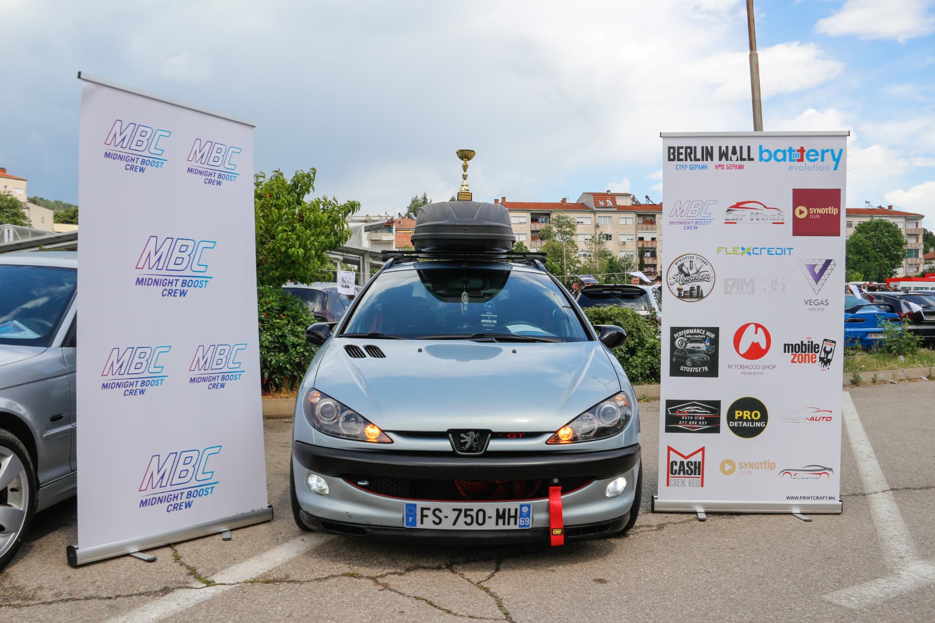 Silver Peugeot 206 with roof box and trophy